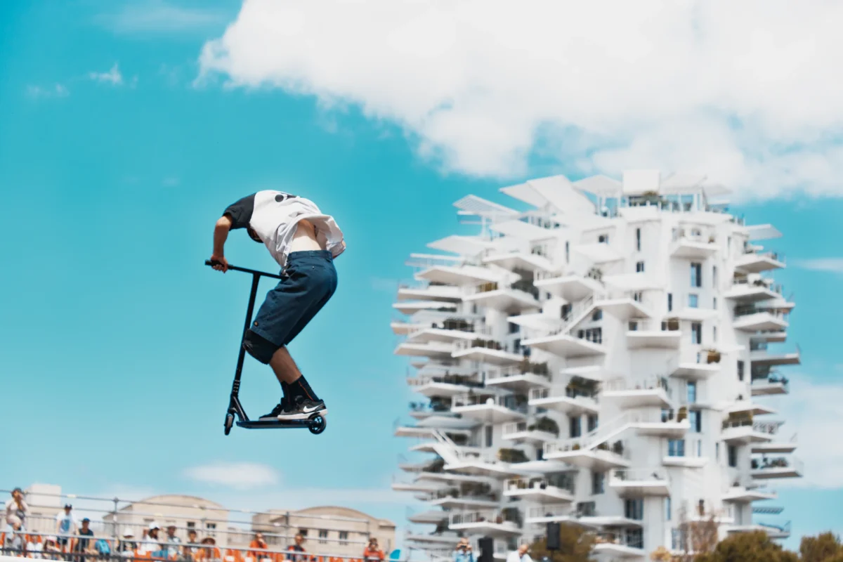 L'Arbre et l'Envol - Photographie d'art trottinette freestyle au FISE avec l'Arbre Blanc de Montpellier en arrière-plan