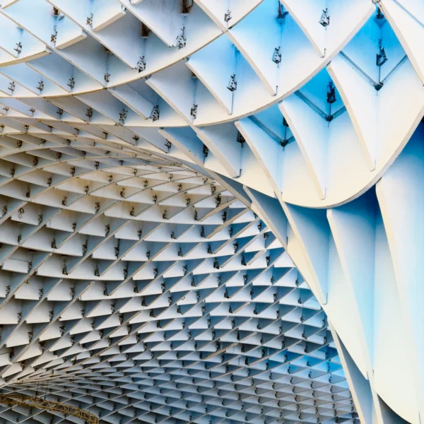 Photographie d'art géométrique et alvéolaire du Metropol Parasol à Séville (Las Setas), avec un traitement de couleur inversé en bleu électrique et jaune doré.
