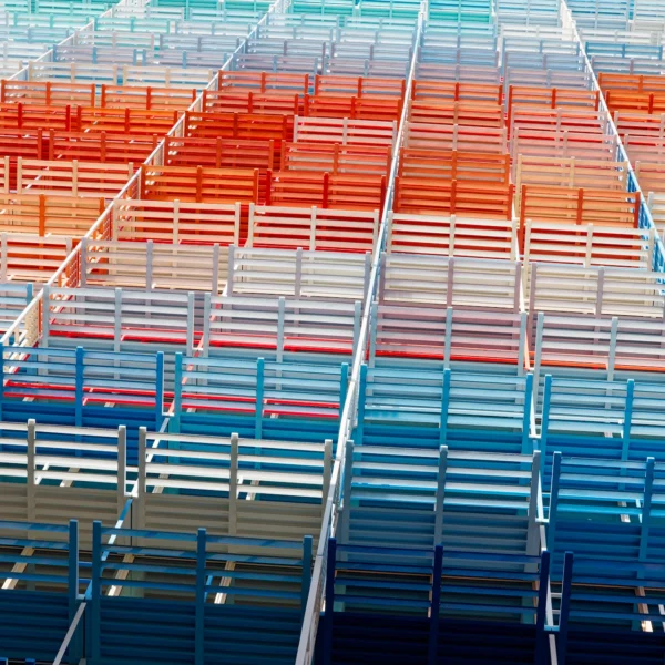 Gros plan abstrait et géométrique sur la façade colorée de la tour La Marseillaise, motif répétitif de grilles bleues, blanches et rouges formant une trame.